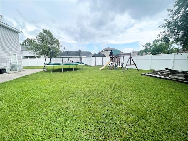 view of yard featuring a patio area, a trampoline, and a playground