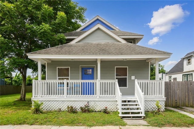 bungalow-style home with covered porch and a front lawn