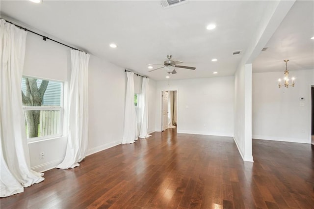 spare room featuring ceiling fan with notable chandelier and dark hardwood / wood-style flooring