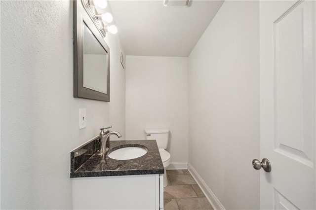 bathroom featuring vanity, toilet, and tile patterned flooring