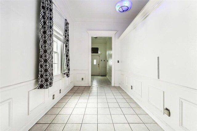 hallway featuring crown molding and light tile patterned floors