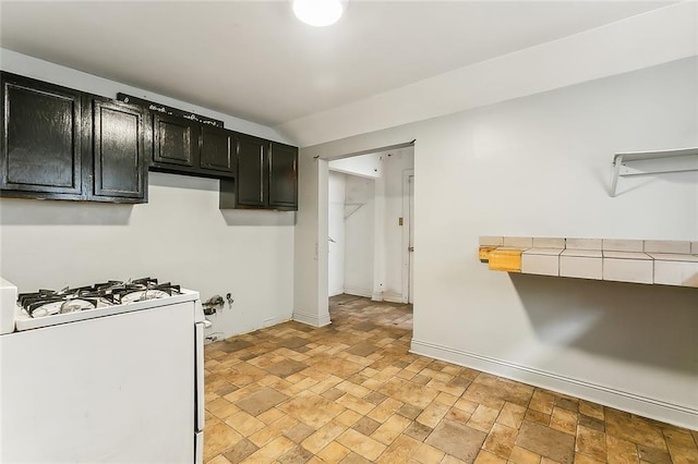 kitchen featuring vaulted ceiling and white gas range