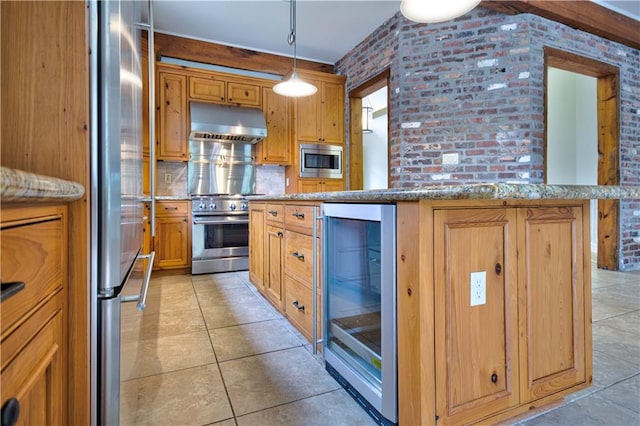 kitchen with hanging light fixtures, beverage cooler, stainless steel appliances, and brick wall