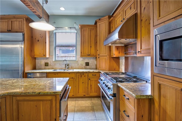 kitchen featuring light tile patterned floors, sink, decorative light fixtures, built in appliances, and light stone countertops