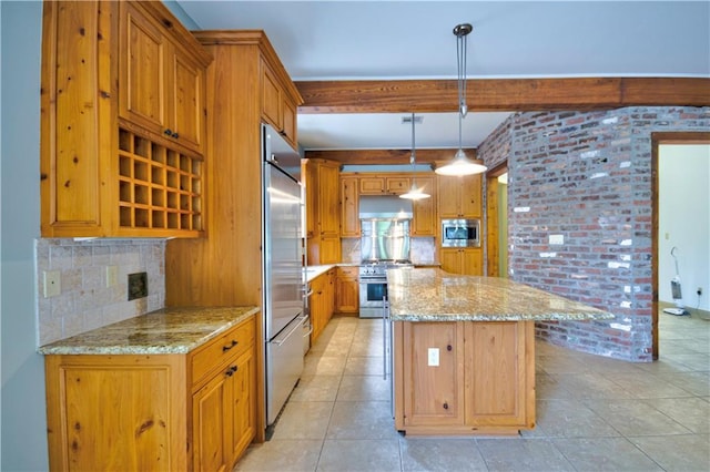 kitchen featuring light stone counters, built in appliances, decorative light fixtures, and a center island