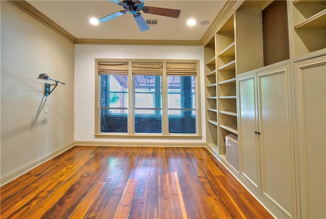 empty room featuring ceiling fan, dark wood-type flooring, and crown molding