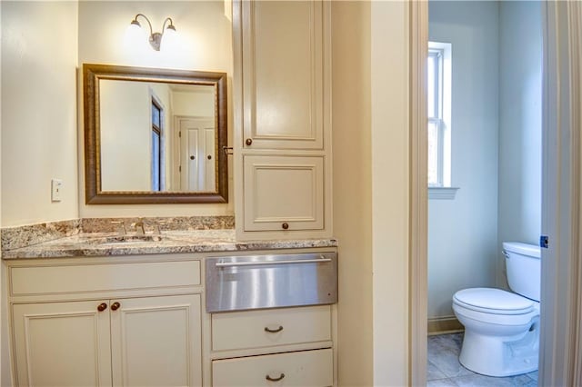 bathroom with tile patterned flooring, vanity, and toilet