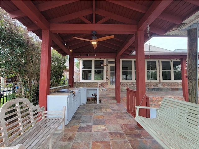 view of patio featuring ceiling fan, an outdoor kitchen, a gazebo, and sink