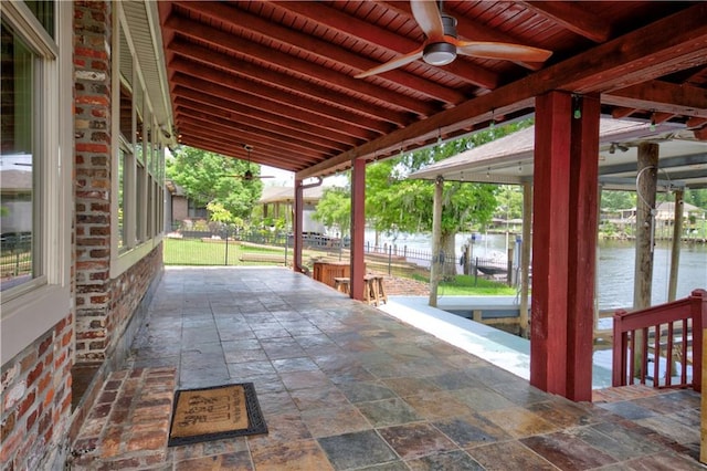 view of patio with a water view and ceiling fan