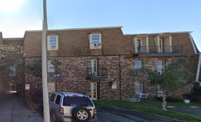 view of front of home featuring a balcony and cooling unit