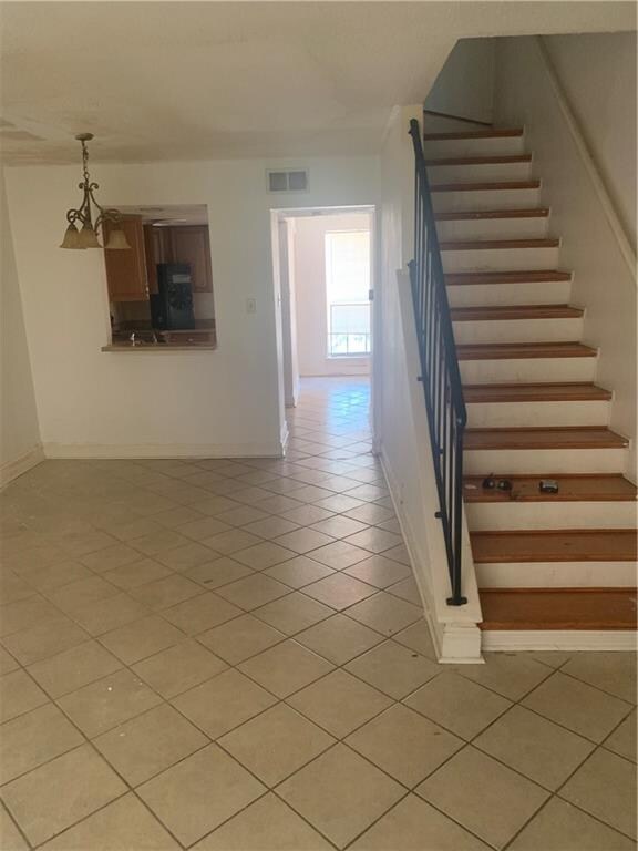 stairs with light tile patterned floors