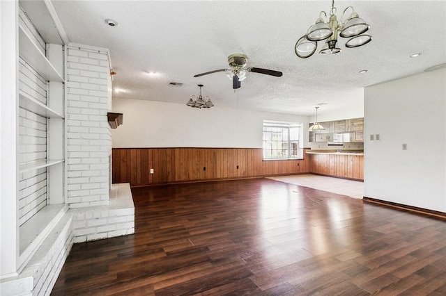 unfurnished living room featuring dark hardwood / wood-style floors, a textured ceiling, and ceiling fan with notable chandelier