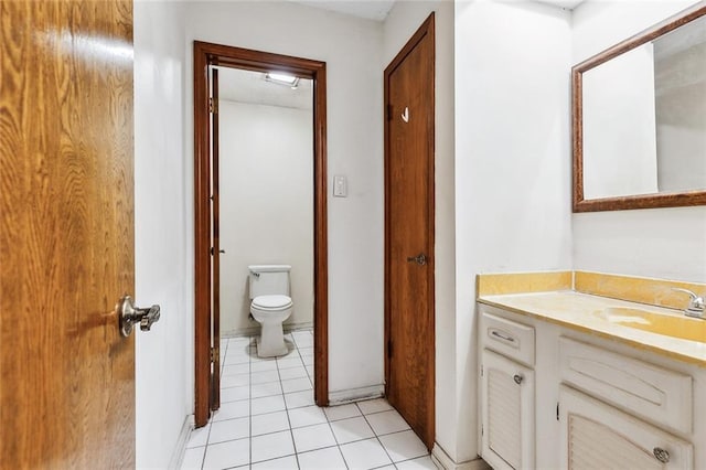 bathroom with toilet, vanity, and tile patterned floors