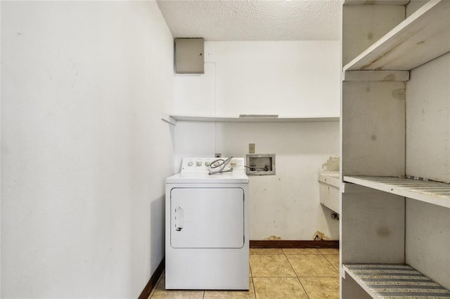 clothes washing area with light tile patterned floors, a textured ceiling, and washer / dryer