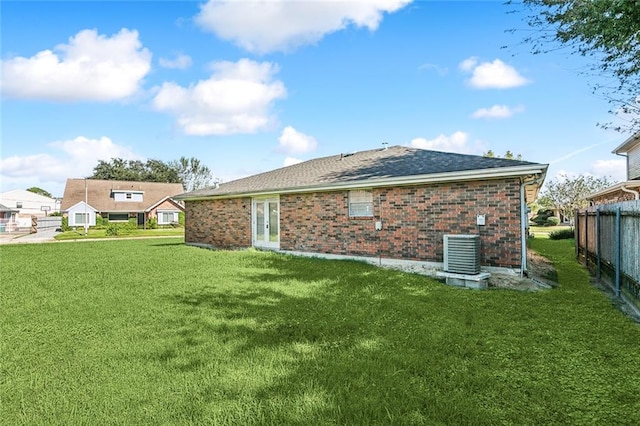 back of house featuring a lawn and cooling unit