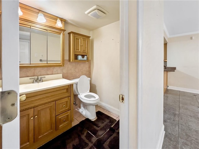 bathroom with tasteful backsplash, toilet, vanity, tile walls, and tile patterned floors