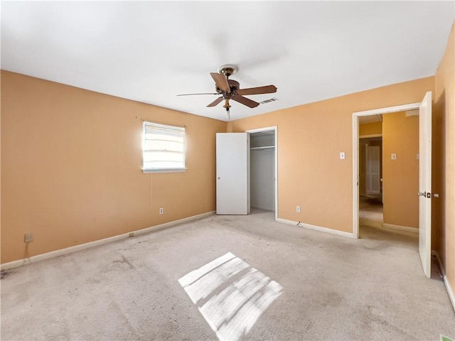 unfurnished bedroom featuring a closet, light colored carpet, and ceiling fan