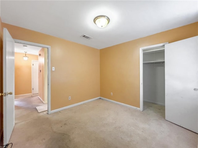 unfurnished bedroom with a closet and light colored carpet