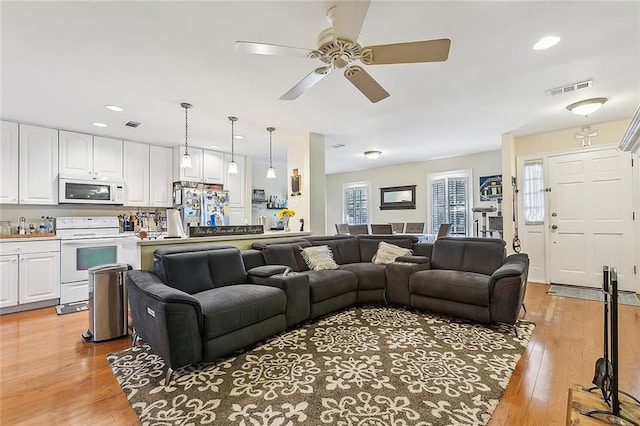 living room with light hardwood / wood-style floors and ceiling fan