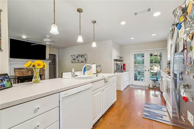 kitchen featuring decorative light fixtures, white cabinetry, ceiling fan, dishwasher, and light hardwood / wood-style flooring