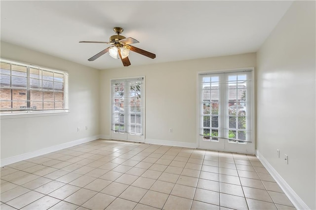 tiled spare room featuring plenty of natural light and ceiling fan