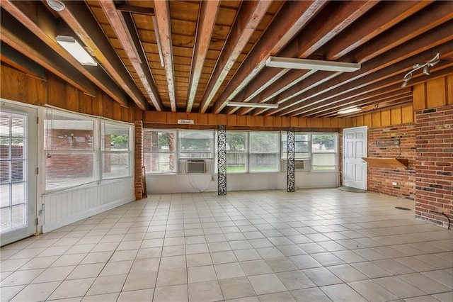 unfurnished sunroom featuring a wealth of natural light, beam ceiling, and cooling unit