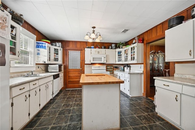 kitchen with sink, dark tile patterned floors, white appliances, and white cabinets