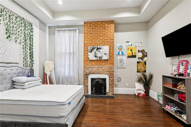 bedroom featuring dark hardwood / wood-style flooring and a fireplace