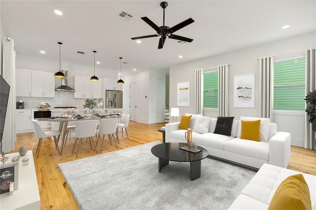 living room with light wood-type flooring and ceiling fan