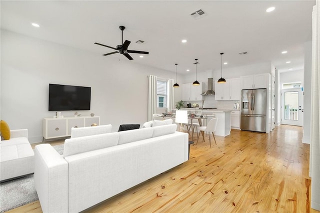 living room with ceiling fan and light hardwood / wood-style floors