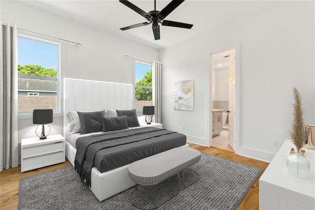 bedroom with light hardwood / wood-style floors, ensuite bathroom, and ceiling fan