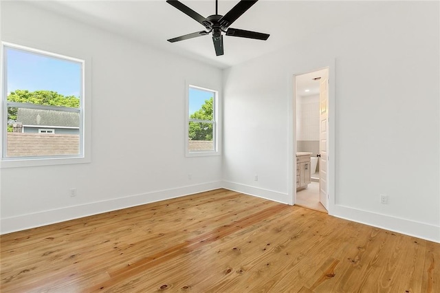 unfurnished bedroom with ensuite bathroom, ceiling fan, and light hardwood / wood-style floors