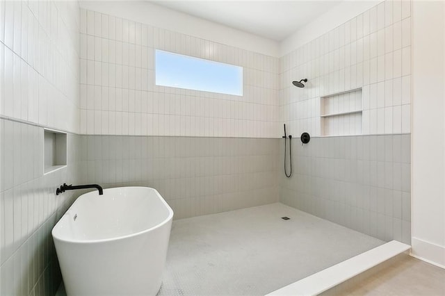 bathroom featuring tile walls and a tile shower