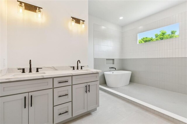 bathroom with tile patterned floors, a tub, and double sink vanity