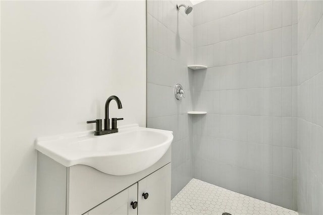 bathroom with vanity and a tile shower