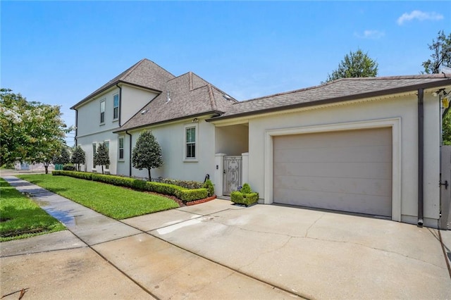 view of front of property with a garage and a front lawn