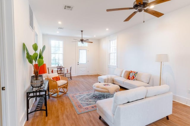 living room with light wood-type flooring and ceiling fan