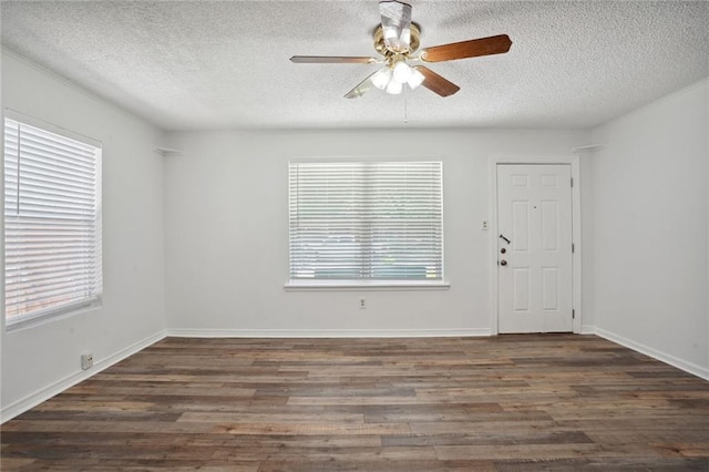 unfurnished room with plenty of natural light, dark hardwood / wood-style floors, ceiling fan, and a textured ceiling