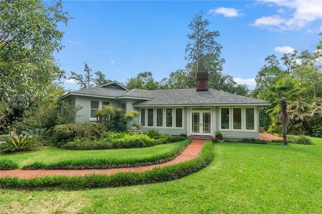 rear view of house featuring a lawn