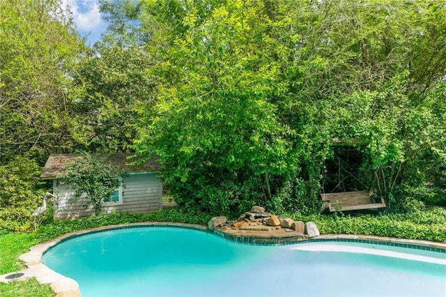 view of swimming pool featuring an outbuilding