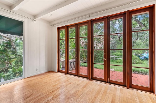 doorway to outside with beamed ceiling, light hardwood / wood-style flooring, and a wealth of natural light