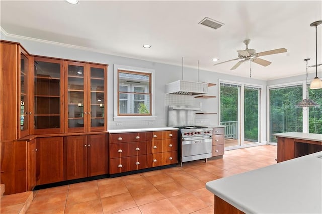 kitchen with light tile patterned floors, luxury stove, ceiling fan, hanging light fixtures, and decorative backsplash