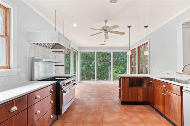 kitchen featuring gas stove, light tile patterned floors, decorative backsplash, decorative light fixtures, and sink