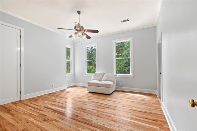 unfurnished room featuring ceiling fan, crown molding, light hardwood / wood-style flooring, and a healthy amount of sunlight