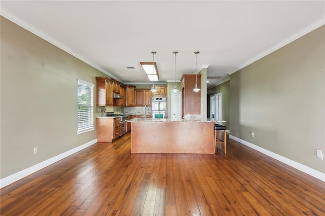 kitchen with a breakfast bar, kitchen peninsula, dark hardwood / wood-style floors, and stainless steel appliances