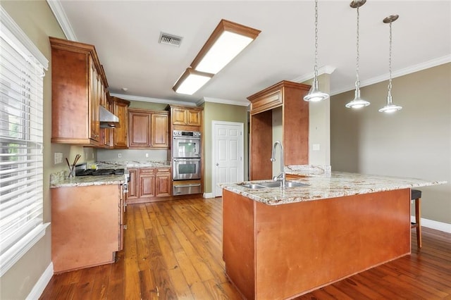 kitchen with pendant lighting, stainless steel double oven, kitchen peninsula, sink, and hardwood / wood-style flooring