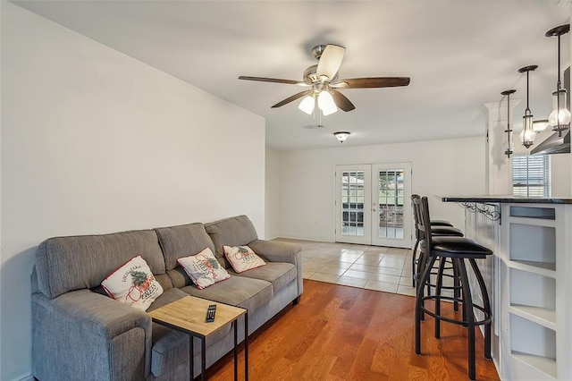 living room with wood-type flooring, french doors, a wealth of natural light, and ceiling fan