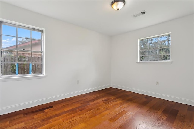 unfurnished room featuring hardwood / wood-style flooring and a healthy amount of sunlight