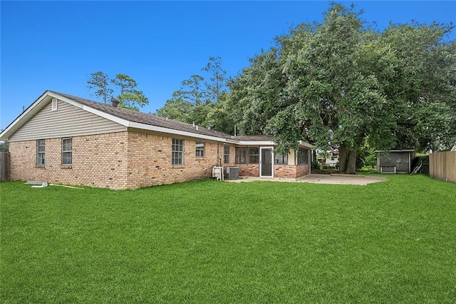 rear view of property featuring a patio, central air condition unit, and a lawn