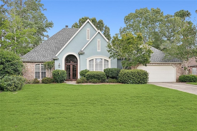 tudor home featuring a garage and a front lawn